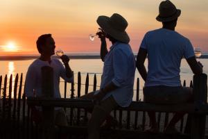 three people sitting on a bench watching the sunset at Villa du Pyla in Pyla-sur-Mer