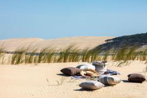 a group of rocks sitting on a sandy beach at Villa du Pyla in Pyla-sur-Mer