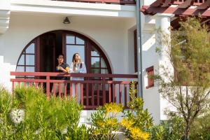 two people standing on a balcony of a house at Villa du Pyla in Pyla-sur-Mer