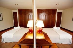 2 camas en una habitación con 2 lámparas en las mesas en Apartamentos Turísticos Las Nieves Playa, en Llanes