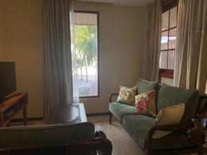 a living room with a green couch and a window at Viluveli Holiday Retreat in Hanimaadhoo