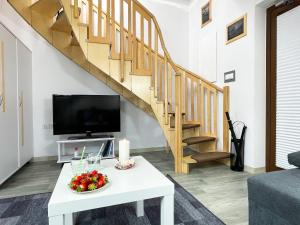 ein Wohnzimmer mit einem weißen Couchtisch und einer Treppe in der Unterkunft Apartamenty Nadrzeczna24 in Tolkmicko