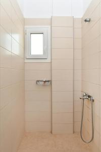 uma casa de banho com um chuveiro e uma janela em Sandaya Living - M Apartment em Naousa