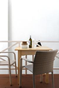 uma mesa com duas cadeiras e uma garrafa de vinho em Sandaya Living - M Apartment em Naousa