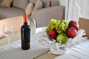 uma garrafa de vinho e uma taça de fruta numa mesa em Sandaya Living - M Apartment em Naousa