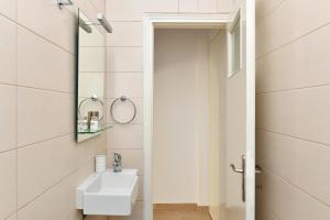 uma casa de banho com um lavatório branco e um espelho. em Sandaya Living - M Apartment em Naousa