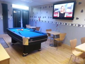a billiard room with a pool table and a tv at The Penrhyn in Blackpool