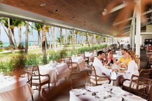 un gruppo di persone seduti ai tavoli in un ristorante di Barceló Bávaro Beach - Adults Only All Inclusive a Punta Cana