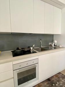 a kitchen with white cabinets and a sink at Aura Marina Casa Vacanze in Polignano a Mare