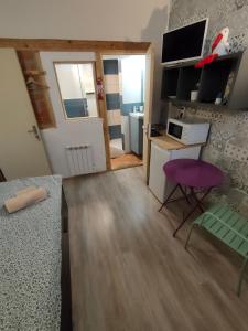 Kleines Zimmer mit einem Schreibtisch und einem lila Stuhl in der Unterkunft La Provence Studio in Colmar