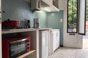 a kitchen with a red microwave and a stove at Carrer del Sol in Sainte-Marie-la-Mer