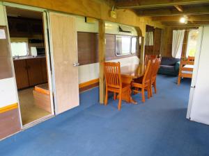 ein Esszimmer mit einem Tisch und Stühlen in einem Wohnwagen in der Unterkunft Matauri Bay Holiday Park in Matauri Bay