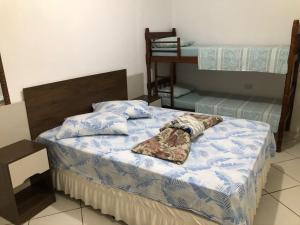 a bed with a blanket on it in a room at Pousada sol in Torres