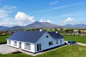 a white house with mountains in the background at Quintenvale House in Kilkeel