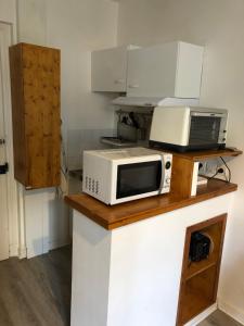 a microwave sitting on top of a counter at Mont-Dore : Studio calme face aux thermes in Le Mont-Dore