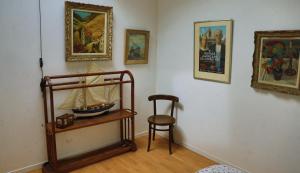 ein Zimmer mit einem Stuhl und einem Modellboot auf einem Regal in der Unterkunft les coquilles in Lanton