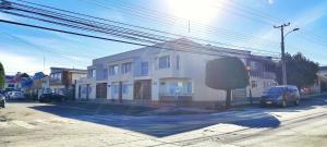 a white house on the side of a street at Casa nueva, excelente ubicación in Punta Arenas