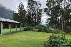 uma casa verde num quintal com um relvado verde em Ti' Kaz Kréol em Salazie