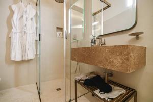 a bathroom with a sink and a shower with a mirror at BAYIT Charming Place in Polignano a Mare
