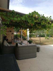 une terrasse avec une pergola, une table et des chaises dans l'établissement Au Doux Repos, à Lucbardez-et-Bargues