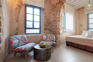 a bedroom with a bed and a table and chairs at Arabesque House in ‘Akko