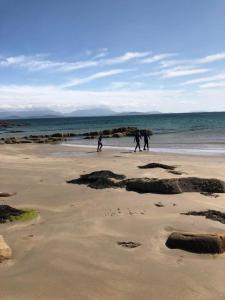 a group of people walking on the beach at Doughbeg Beach Cottage in Mulranny