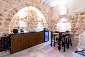 eine Küche mit einem Tisch und Stühlen in einer Steinmauer in der Unterkunft Arabesque House in Akkon