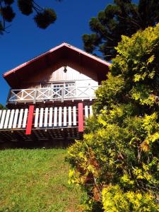 ein weißes und rotes Gebäude mit rotem Dach in der Unterkunft Florada na Serra in Monte Verde