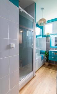 een badkamer met een douche en een glazen deur bij Oasis Anjou in Saumur