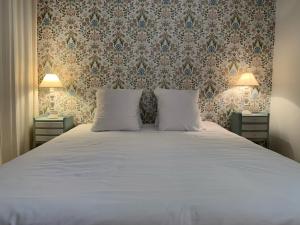 1 dormitorio con 1 cama grande y 2 mesitas de noche en Appart Hôtel La vie est belle, en Lalinde