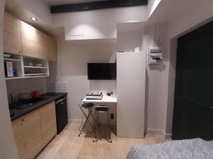 een kleine keuken met een witte koelkast en een tafel bij la studette du théâtre in Boulogne-Billancourt