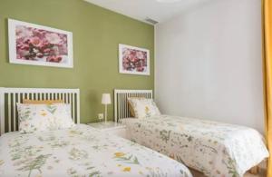 two beds in a bedroom with green walls at Amazing City Center Apartment in Málaga