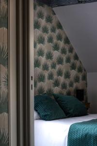 a bedroom with a bed with a headboard and green pillows at Maison d'Hôte la Vie Est Belle in Lalinde