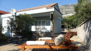 a patio with a bench and a house at 35 meters from sea Apartment Keser and House for rent in Karlobag +42 photos