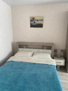 a bedroom with a bed with blue and white stripes at Уютные апартаменты на Речном in Tver