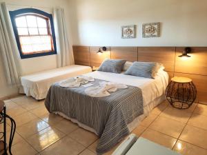 a bedroom with a bed with towels on it at Pousada Luz do Sol in Carrancas