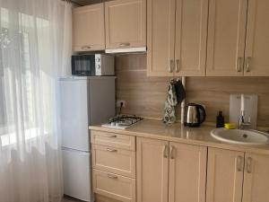 a kitchen with a white refrigerator and a sink at Уютные апартаменты на Речном in Tver