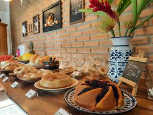 a table topped with different types of bread on plates at Pousada Luz do Sol in Carrancas