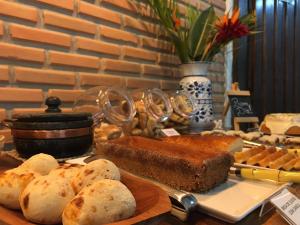 a table topped with bread and other baked goods at Pousada Luz do Sol in Carrancas