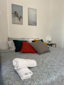 a bed with a pile of towels on it at Liberty Hostel Lisbon in Lisbon