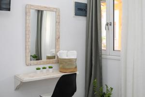 a bathroom with a mirror and a table with a sink at Aura Skiathos in Skiathos