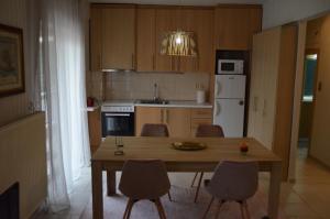 una pequeña cocina con mesa de madera y sillas en STEFANIAS HOUSE, en Tesalónica