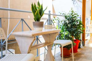 una mesa y sillas en un balcón con plantas en Aura Skiathos en Skiathos