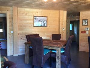 a dining room with a wooden table and chairs at La combe in Morzine