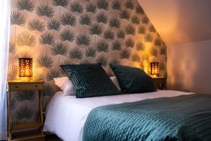 a bedroom with a bed and two lamps on tables at Appart Hôtel La vie est belle in Lalinde