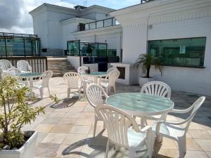 un gruppo di tavoli e sedie su un patio di Aconchegante Apartamento com Vista para o Mar e Nascer do Sol ad Arraial do Cabo