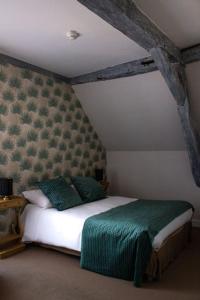 a bedroom with a large bed with green sheets at Maison d'Hôte la Vie Est Belle in Lalinde +2 photos