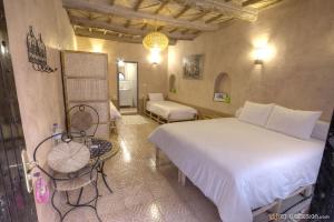 阿伊特本哈杜Guest House Bagdad Café的卧室里有一张白色的大床和一把椅子