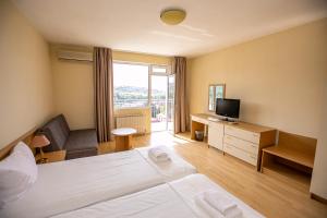 a hotel room with a bed and a television at Hotel Astra in Sandanski
