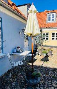 un patio con una mesa y una sombrilla amarilla en Harbour Living West en Ringkøbing